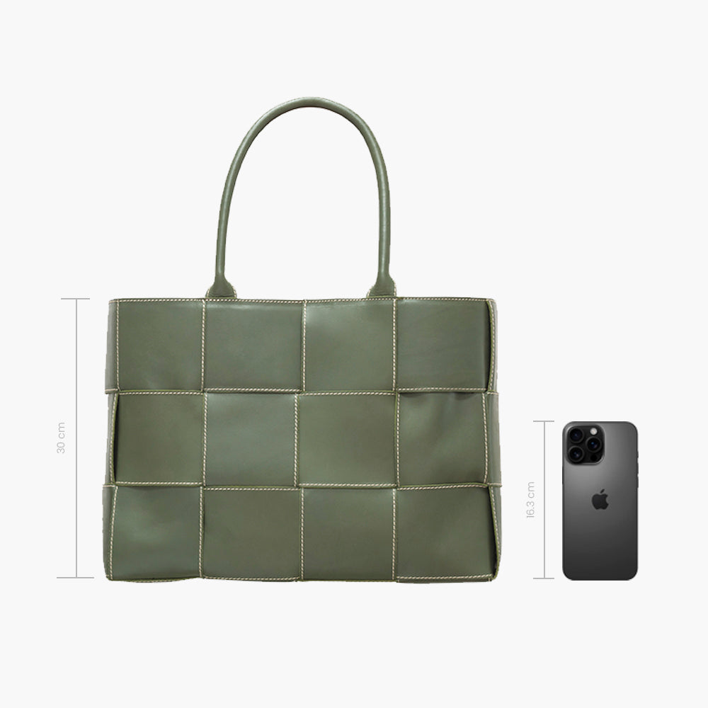 Bolsa tote verde acolchada con diseño de paneles cuadrados y costuras blancas en contraste, asas dobles superiores y estructura amplia rectangular.