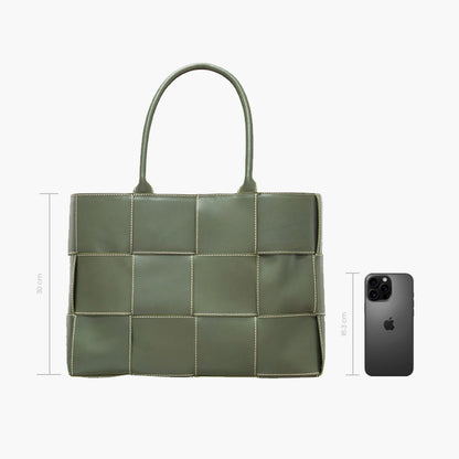 Bolsa tote verde acolchada con diseño de paneles cuadrados y costuras blancas en contraste, asas dobles superiores y estructura amplia rectangular.