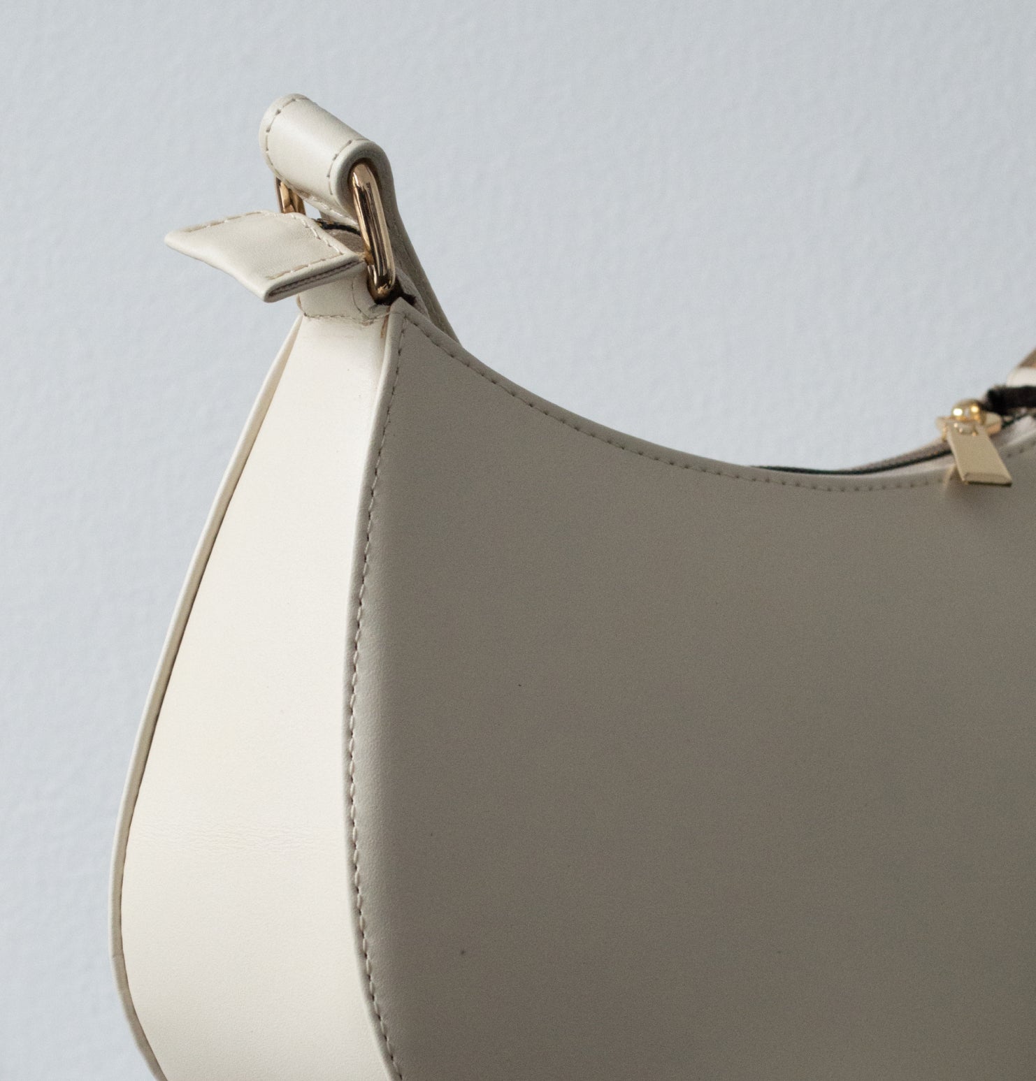 Bolso Thupe beige minimalista con cierre metálico dorado en contexto editorial lifestyle.